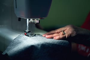 A hand holding a fabric while stiching