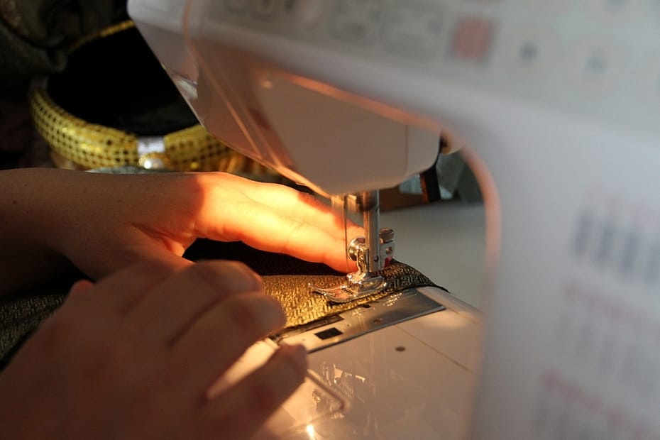 Hands are stitching a cloth